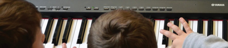 young children playing a keyboard piano